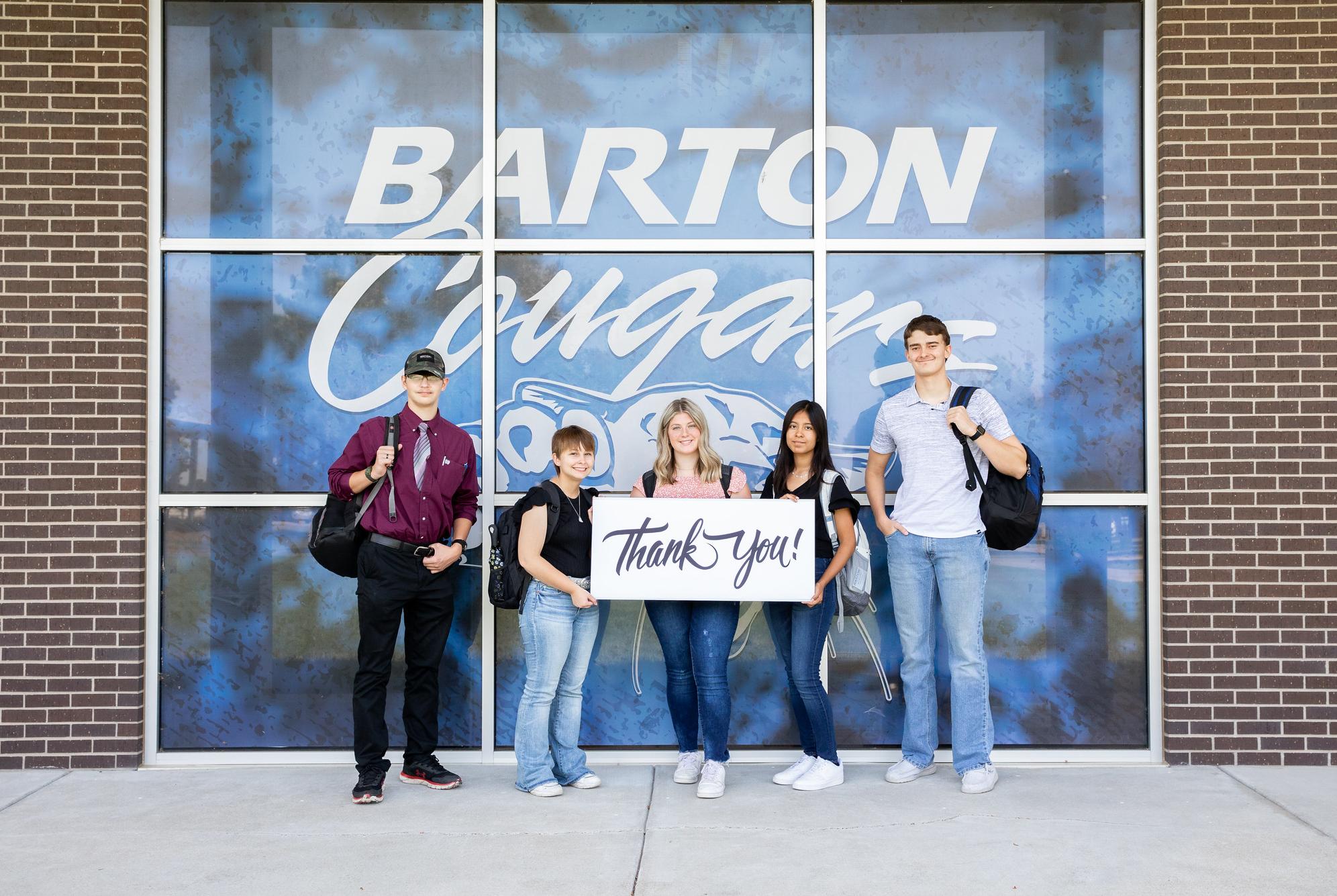 people standing in front a graphic of a cougar