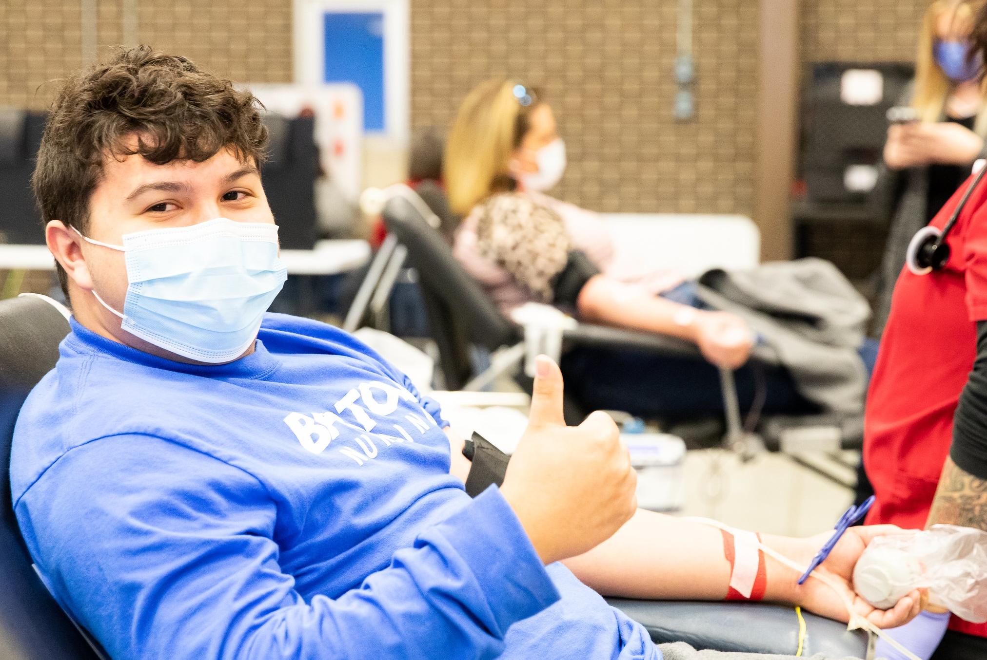 blood donor donating blood with a thumbs up