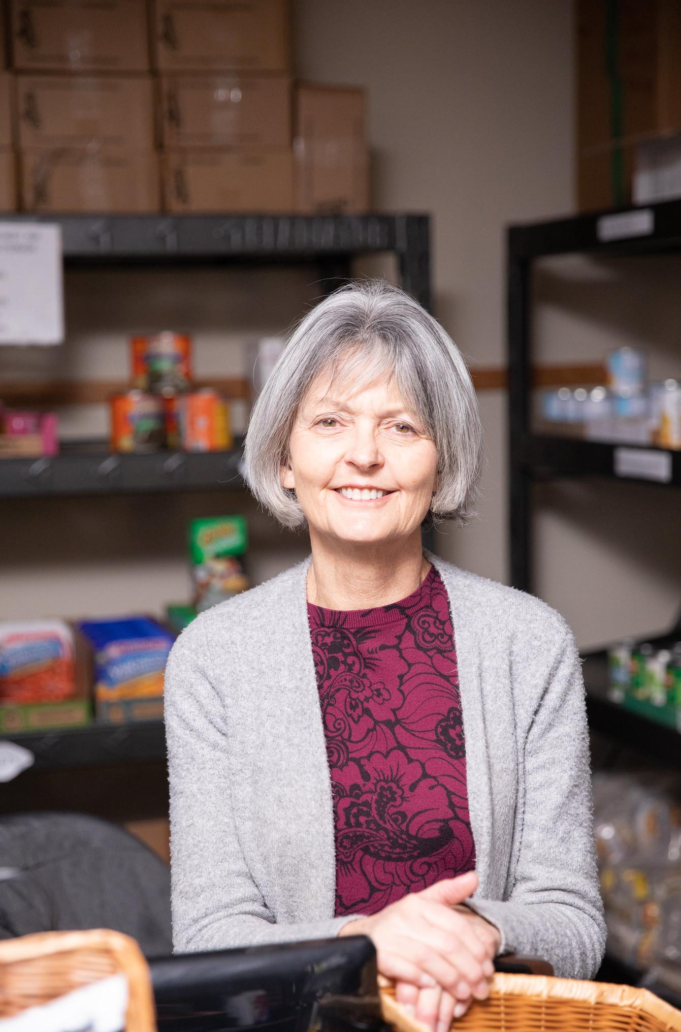 lady smiles in the cougar supply den with supplies in the background