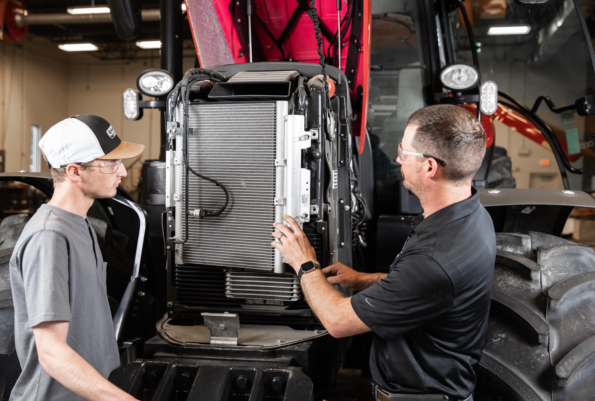 two men working on a tractor