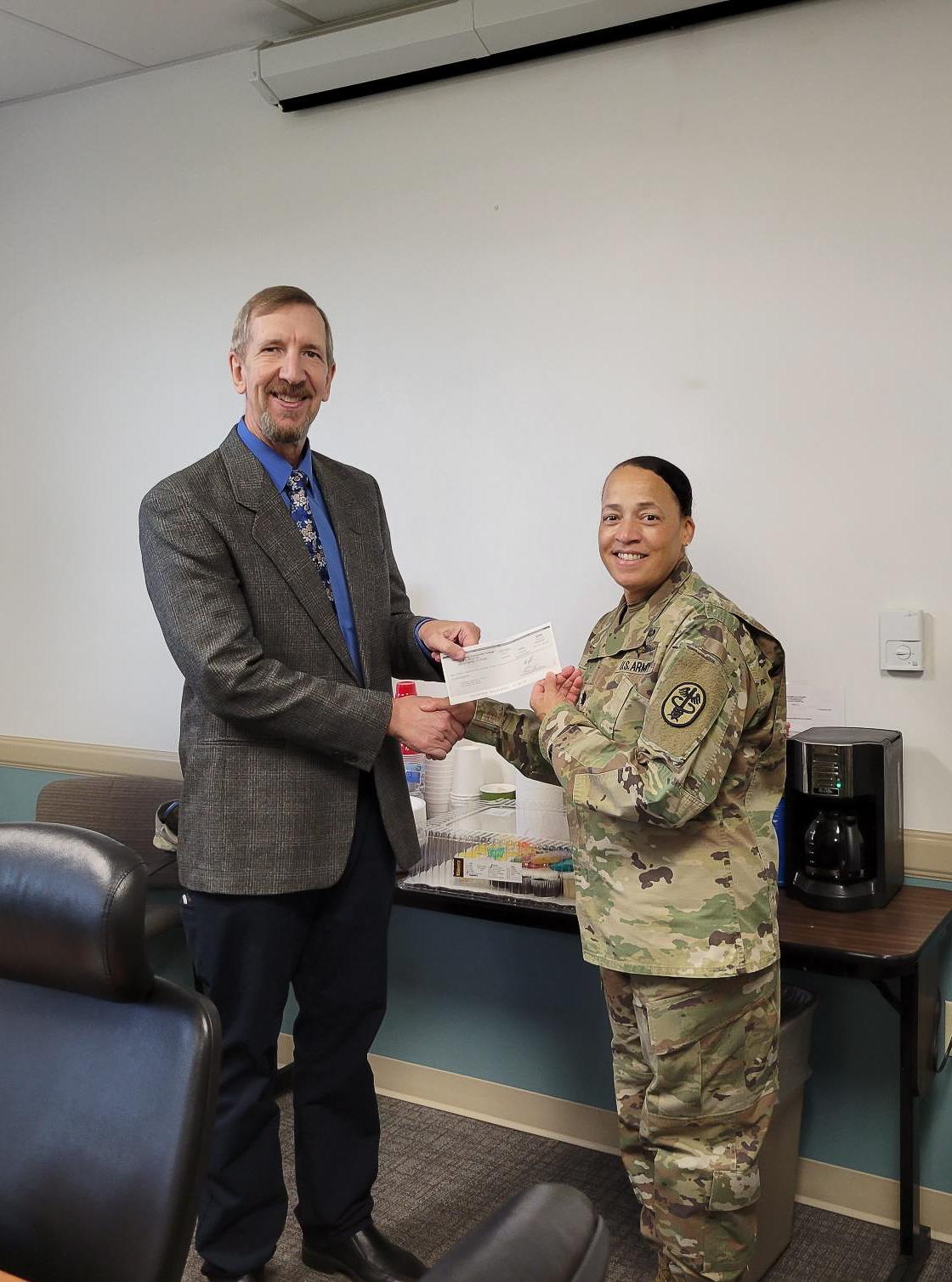 man handing a woman a check